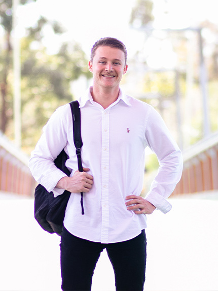 Student standing with black bagpack