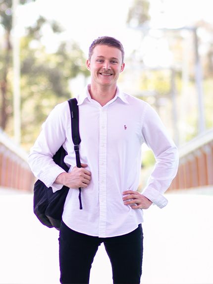 Student standing with black bagpack