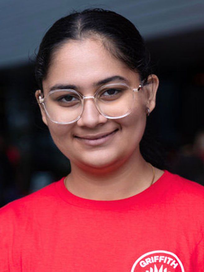 Female student Puneet smiling in red t-shirt
