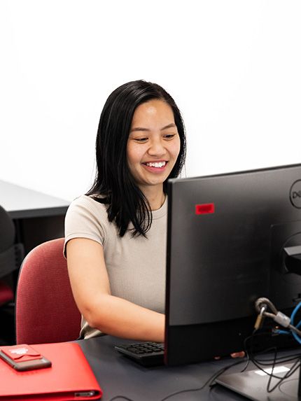 Female student studying computer library happy