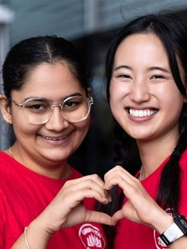 Female students smiling and making heart symbol