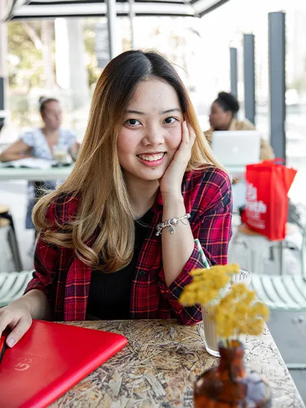 A girl sitting and smiling in front of camera