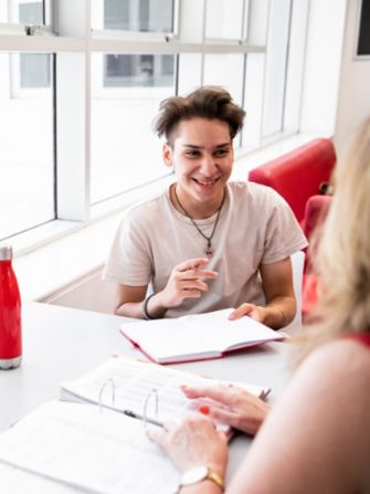 Male student school leaver teacher talking notes