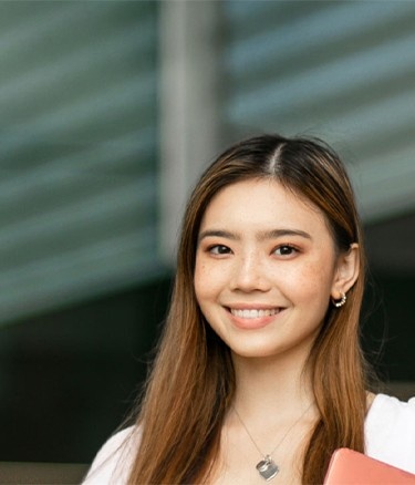 Single girl standing with book
