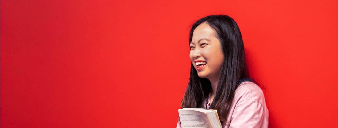 Student happy red wall holding book