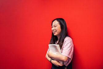 Student happy red wall holding book