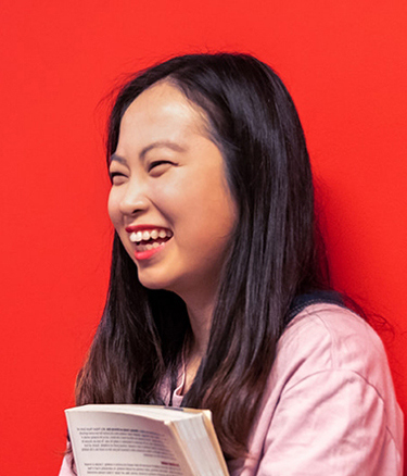 Student happy red wall holding book