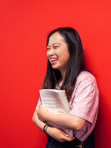 Student happy red wall holding book