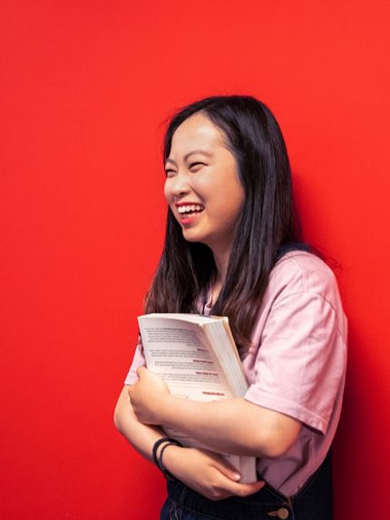 Student happy red wall holding book