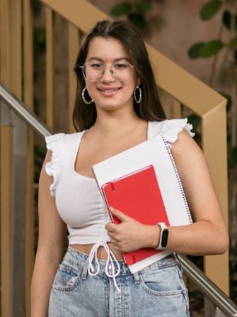 Student outside happy holding books