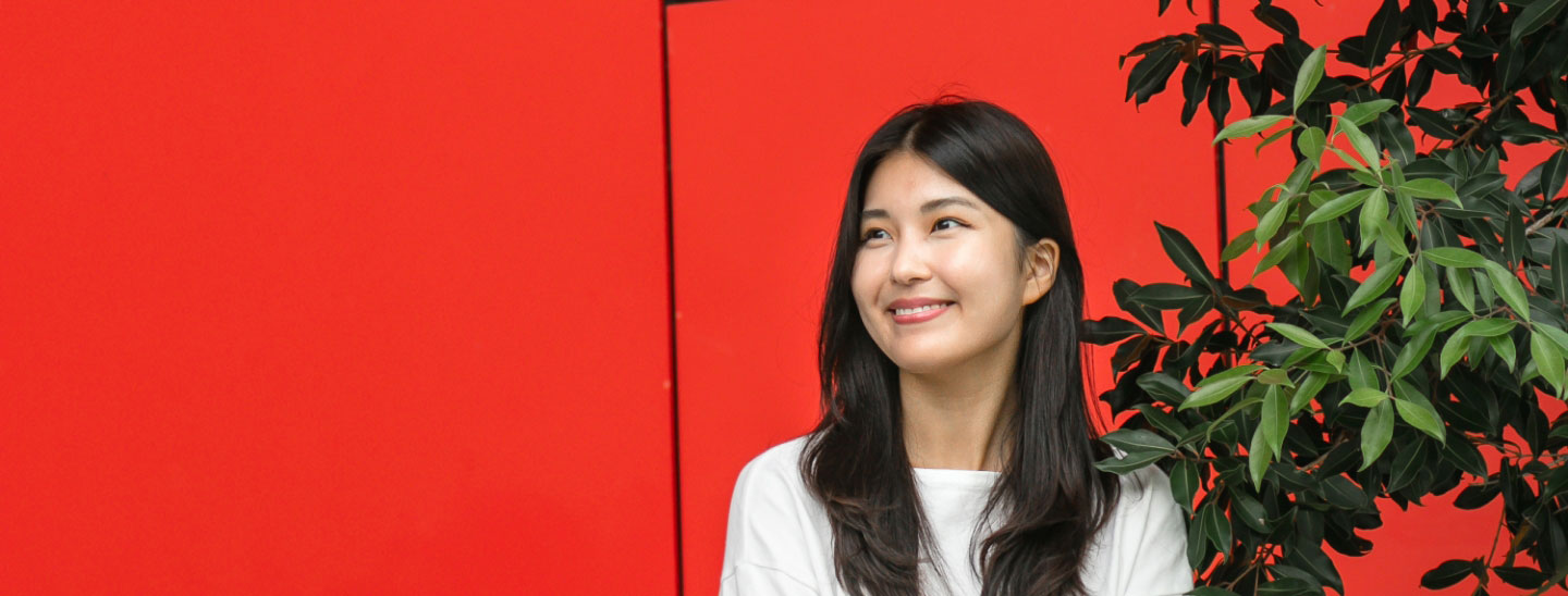 Student outside happy red wall