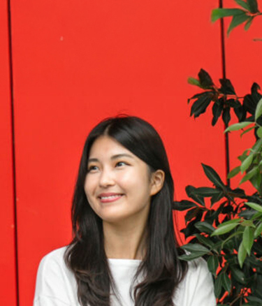 Student outside happy red wall