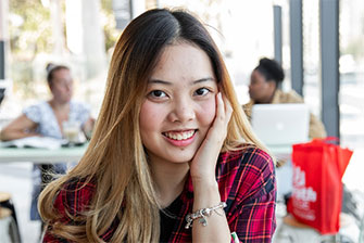 Student outside happy sitting