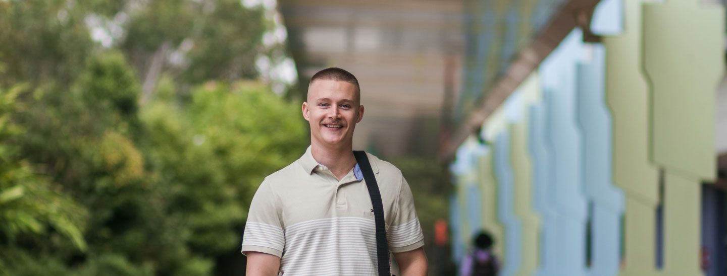 Student outside holding laptop