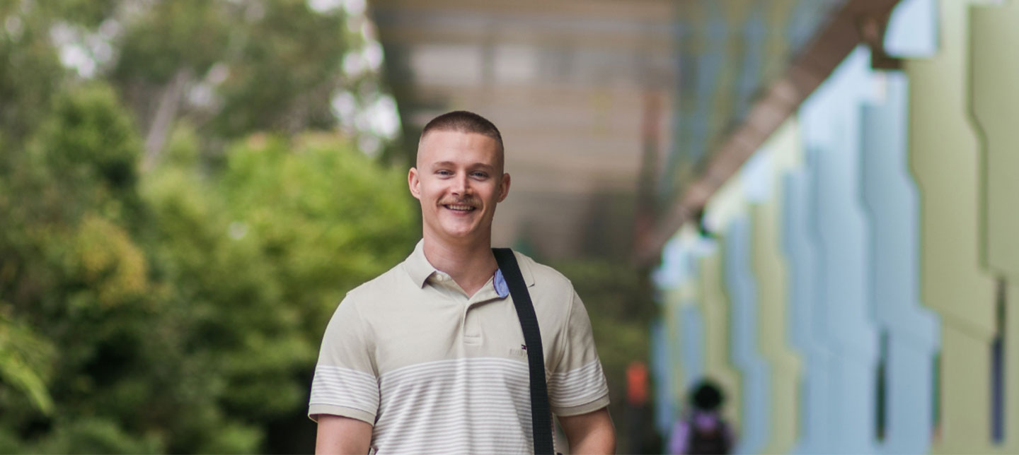 Student outside holding laptop