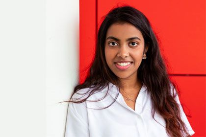 Student outside near red wall