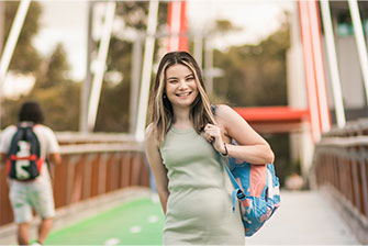 Student outside walking with backpack