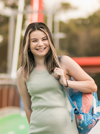 Student outside walking with backpack