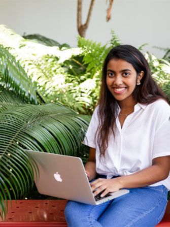 Student sitting-outside laptop happy working