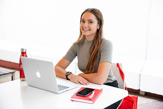 Student working inside on laptop