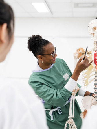 Students inside health lab human skeleton