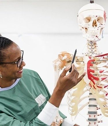 Students inside health lab human skeleton