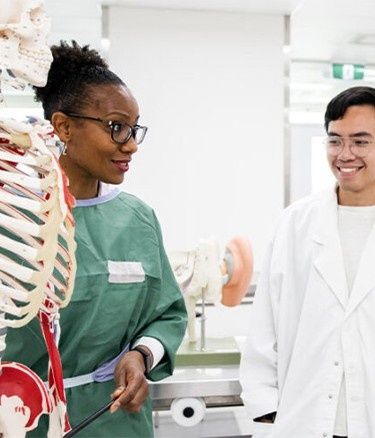 Students inside health lab human skeleton