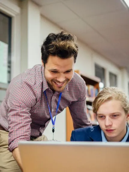 Teacher and student watching on laptop screen