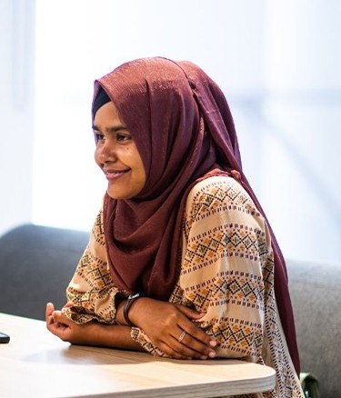 Two women sit across from each other at a table, engaged in conversation.