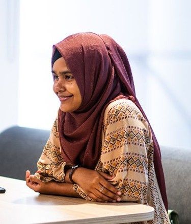 Two women sit across from each other at a table, engaged in conversation.